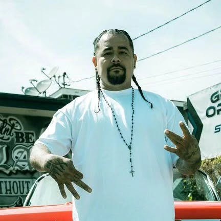 SIN The Artist in front of a lowrider in Norwalk